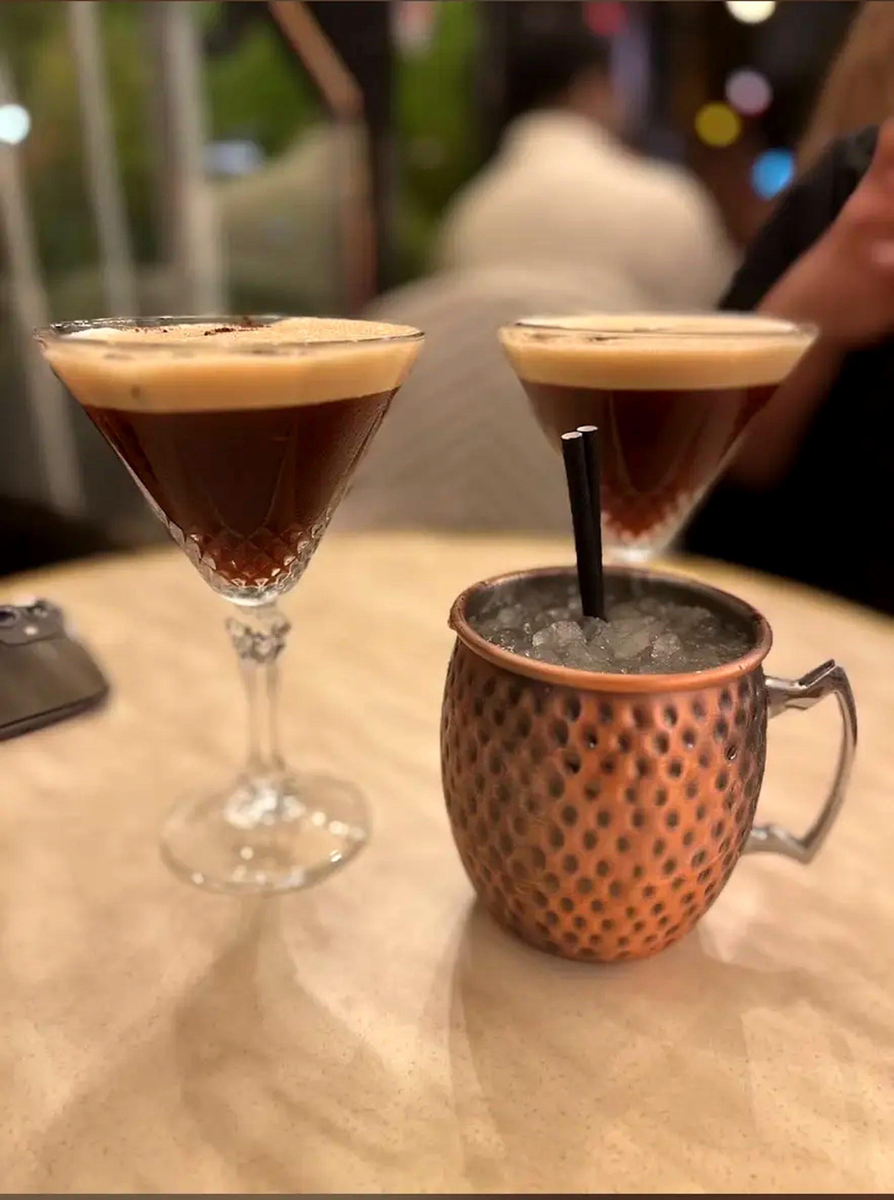 Deux espresso martini et une mule servie au mug cuivré sur une table du Le 40