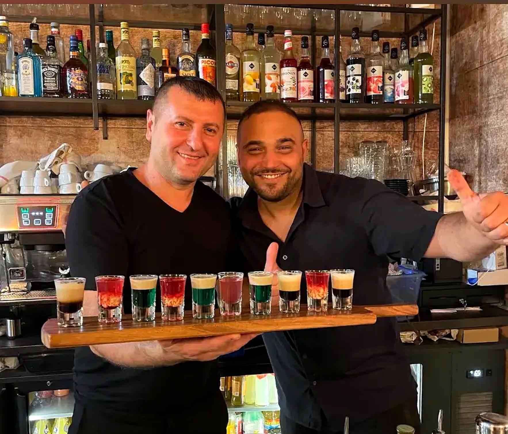 Deux barmen du Le 40 présentant une planche de shots colorés